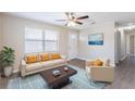 Bright living room with hardwood floors, a ceiling fan, and modern neutral furniture at 3850 11Th S Ave, St Petersburg, FL 33711