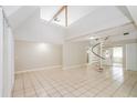 Spacious living room with high ceilings, tile floors, and a unique spiral staircase at 1001 Meadowcrest Dr, Valrico, FL 33594