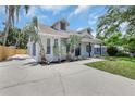 Charming home featuring a well-manicured lawn, complemented by mature palm trees and an inviting driveway at 4413 W Wallcraft Ave, Tampa, FL 33611