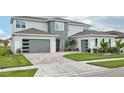 Modern home with a two-car garage and well-kept lawn with a beautiful driveway at 9201 Sanders Tree Loop, Wesley Chapel, FL 33545