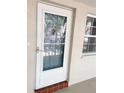 Front door with glass insert and an adjacent window allowing for plenty of natural light at 821 Patricia Ave # 202, Dunedin, FL 34698