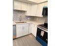 Updated kitchen with stainless steel appliances, modern countertops, and decorative backsplash at 821 Patricia Ave # 202, Dunedin, FL 34698