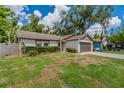 Inviting single-story home featuring a two-car garage, simple landscaping, and side yard fence at 7814 34Th E Ct, Sarasota, FL 34243