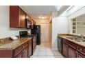 Functional kitchen with granite countertops, wood cabinetry, and modern black appliances at 7814 34Th E Ct, Sarasota, FL 34243