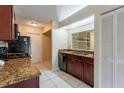 Well-lit kitchen with granite countertops, stainless steel sink, and black appliances at 7814 34Th E Ct, Sarasota, FL 34243