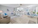 Bright and airy living room featuring neutral decor, tile flooring, and open-concept design to the kitchen at 11923 Boynton Ln # B, New Port Richey, FL 34654