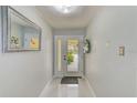 Bright foyer with a glass front door and white tile floors that leads into the home at 150 Brent Cir, Oldsmar, FL 34677