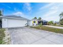 Exterior view showing a 2-car garage and driveway leading up to a charming home under a bright sky at 456 Sandlewood Dr, Venice, FL 34293