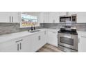 Modern kitchen with stainless steel appliances, sleek cabinetry, and stylish backsplash at 456 Sandlewood Dr, Venice, FL 34293