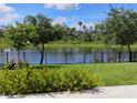 Lush backyard with manicured landscaping, decorative fence, and serene water view at 5150 San Palermo Dr, Bradenton, FL 34208