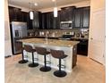 Eat-in kitchen featuring a large island, granite counters, stainless appliances, and dark cabinetry at 13642 Newport Shores Dr, Hudson, FL 34669