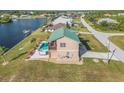 Aerial view of a waterfront home with a pool and spa, nestled on a canal at 15340 Alsask Cir, Port Charlotte, FL 33981