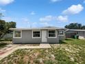 Charming home featuring a front yard with green grass and a neatly painted exterior with white trim at 4432 W Wallace Ave, Tampa, FL 33611
