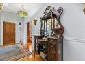 Elegant foyer featuring a vintage mirror cabinet, hardwood floors, and a decorative chandelier at 8407 Interbay Blvd, Tampa, FL 33616