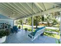 Spacious covered porch featuring a porch swing, ceiling fans, and comfortable seating at 8407 Interbay Blvd, Tampa, FL 33616