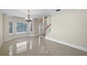 Bright living room with tile floor, staircase and large front window at 11356 Callaway Pond Dr, Riverview, FL 33579