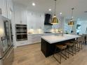 Modern kitchen with stainless steel appliances, a black island, and stylish pendant lighting at 1409 S Moody Ave # 1, Tampa, FL 33629