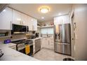 Modern kitchen featuring stainless steel appliances, custom cabinets, and marble countertops at 4203 Fairway Run, Tampa, FL 33618