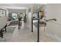 Open-concept living space featuring modern railings, tile flooring, and views of the outdoor patio at 4203 Fairway Run, Tampa, FL 33618