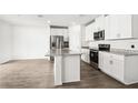 Bright kitchen featuring granite countertops, stainless steel appliances, and a functional kitchen island at 1844 Brekey Way, Zephyrhills, FL 33541