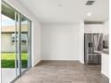 Bright eat-in kitchen with stainless steel appliances and access to outdoor space via sliding glass doors at 1844 Brekey Way, Zephyrhills, FL 33541