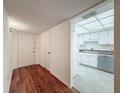 View of the unit's entry with wood floors leading to a bright kitchen at 1200 Tarpon Woods Blvd # L4, Palm Harbor, FL 34685