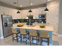 Bright, modern kitchen with stainless steel appliances, quartz countertops, and a center island with seating at 2729 Gabel Oak Dr, North Port, FL 34289