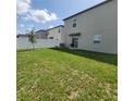 A cozy backyard with a white privacy fence, green grass, and a small seating area at 13707 Newbridge St, Spring Hill, FL 34609