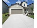 Exterior of a well-maintained two-story home with a wide driveway, landscaped yard and gray exterior at 13707 Newbridge St, Spring Hill, FL 34609