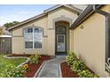 Close-up of the front door with decorative brick accents, lush landscaping, and a well-manicured lawn at 1716 Westerly Dr, Brandon, FL 33511