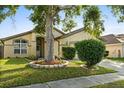 Inviting one-story home with lush landscaping, mature trees, a two-car garage and a cozy front porch at 1716 Westerly Dr, Brandon, FL 33511