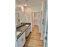 Bathroom featuring double sinks with granite countertops, walk-in closet, and a walk-in shower at 9937 Aqua Miles Path, Wesley Chapel, FL 33545