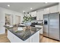 Bright kitchen featuring granite countertops, stainless steel appliances and white cabinets at 9937 Aqua Miles Path, Wesley Chapel, FL 33545