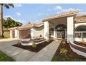 Charming exterior with a well-maintained yard, walkway to arched front door and two-car garage at 17032 Winners Cir, Odessa, FL 33556