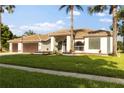 Stunning one-story home features green lawn, palm trees and a two car garage at 17032 Winners Cir, Odessa, FL 33556