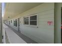 This hallway features a warning sign, painted walls, and a white railing at 2257 World Parkway W Blvd # 61, Clearwater, FL 33763