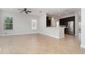 Open-concept living space featuring tile floors, modern ceiling fan, and seamless access to kitchen area at 11314 Grand Park Ave, Riverview, FL 33578