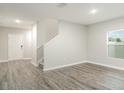 Open living room with neutral walls, gray wood floors, lots of natural light and stairway to the second floor at 12829 Scarlet Star Dr, Riverview, FL 33579