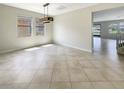 Open dining room with tile flooring, modern light fixture, and large windows with natural sunlight at 19491 Paddock View Dr, Tampa, FL 33647