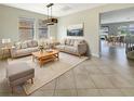 Bright living room featuring neutral furniture, tile floors, and natural light from multiple windows overlooking the yard at 19491 Paddock View Dr, Tampa, FL 33647