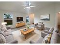 Cozy living room boasts plush seating, a ceiling fan, and bright natural light at 9855 Morris Glen Way, Temple Terrace, FL 33637