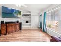 Bright living room with wood floors, built-in shelves, and large window at 15364 Mount Sparrow Rd, Weeki Wachee, FL 34614
