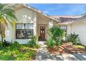 Close-up of the front door with a decorative wreath, surrounded by lush greenery at 2556 Arborwood Dr, Valrico, FL 33596