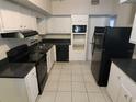 Traditional kitchen featuring white cabinetry and black appliances at 8035 Robin Rd, Seminole, FL 33777