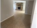 Spacious living room featuring a stone fireplace, neutral tile, and access to other rooms at 9825 Sandstone Ln, Port Richey, FL 34668