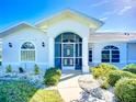 Close-up showcasing the home's arched, screened entry, complemented by stylish windows and fresh landscaping at 142 Broadmoor Ln, Rotonda West, FL 33947
