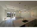 Modern kitchen with a center island, pendant lighting, and stainless steel sink at 1495 Craleigh St, North Port, FL 34288