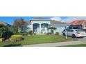 Beautiful one-story home with a blue exterior, landscaped front yard, and a two-car garage at 1884 Coconut Palm Cir, North Port, FL 34288