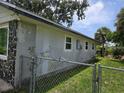 Side of the home featuring the unique stone facade, complemented by a metal chain link fence at 2308 18Th E St, Bradenton, FL 34208