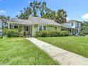 Charming single Gathering home with a green lawn, walkway, and lush green shrubbery at 2710 W North A St, Tampa, FL 33609